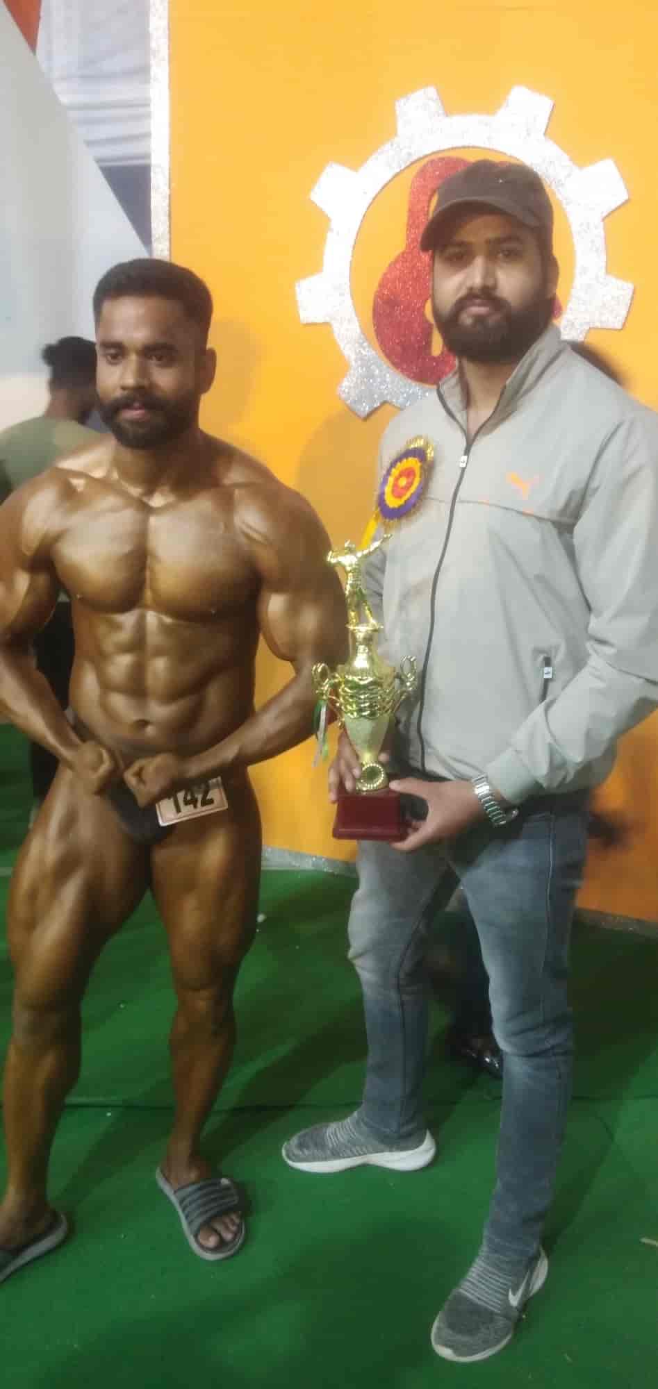 Dynamic Unisex Gym coach and athlete championship celebration with trophy on stage